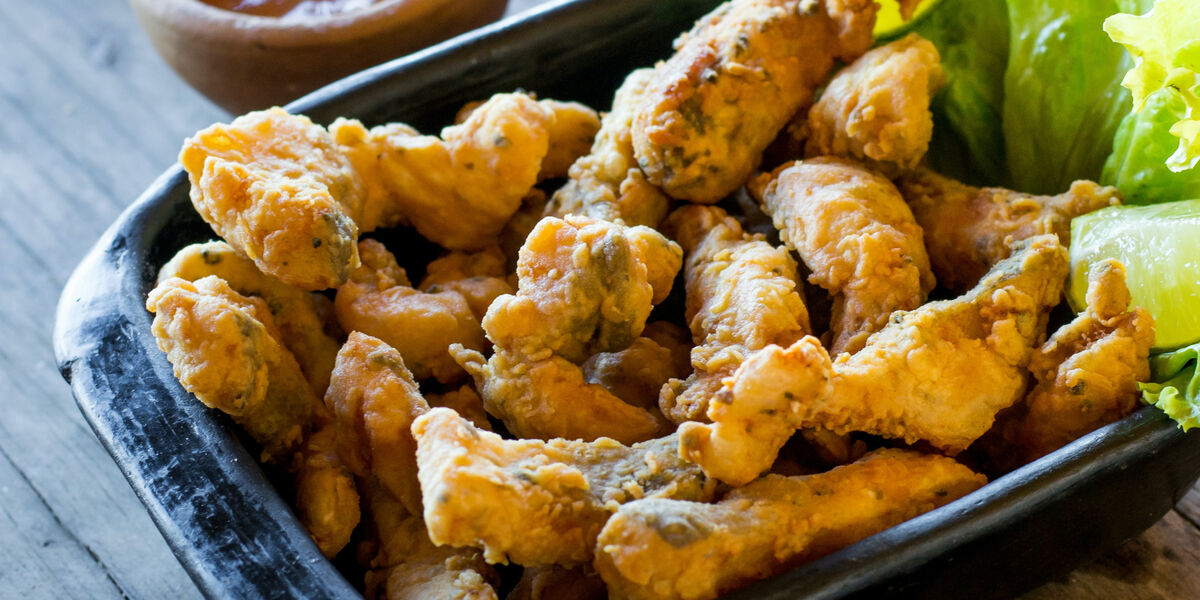 A serving of fried wild caught fish with a side of marinara